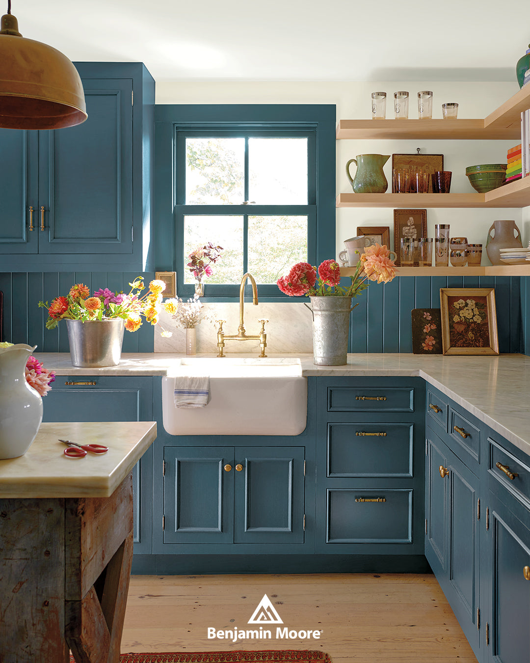 a remodelled kitchen with blue cabinets with gold hardware